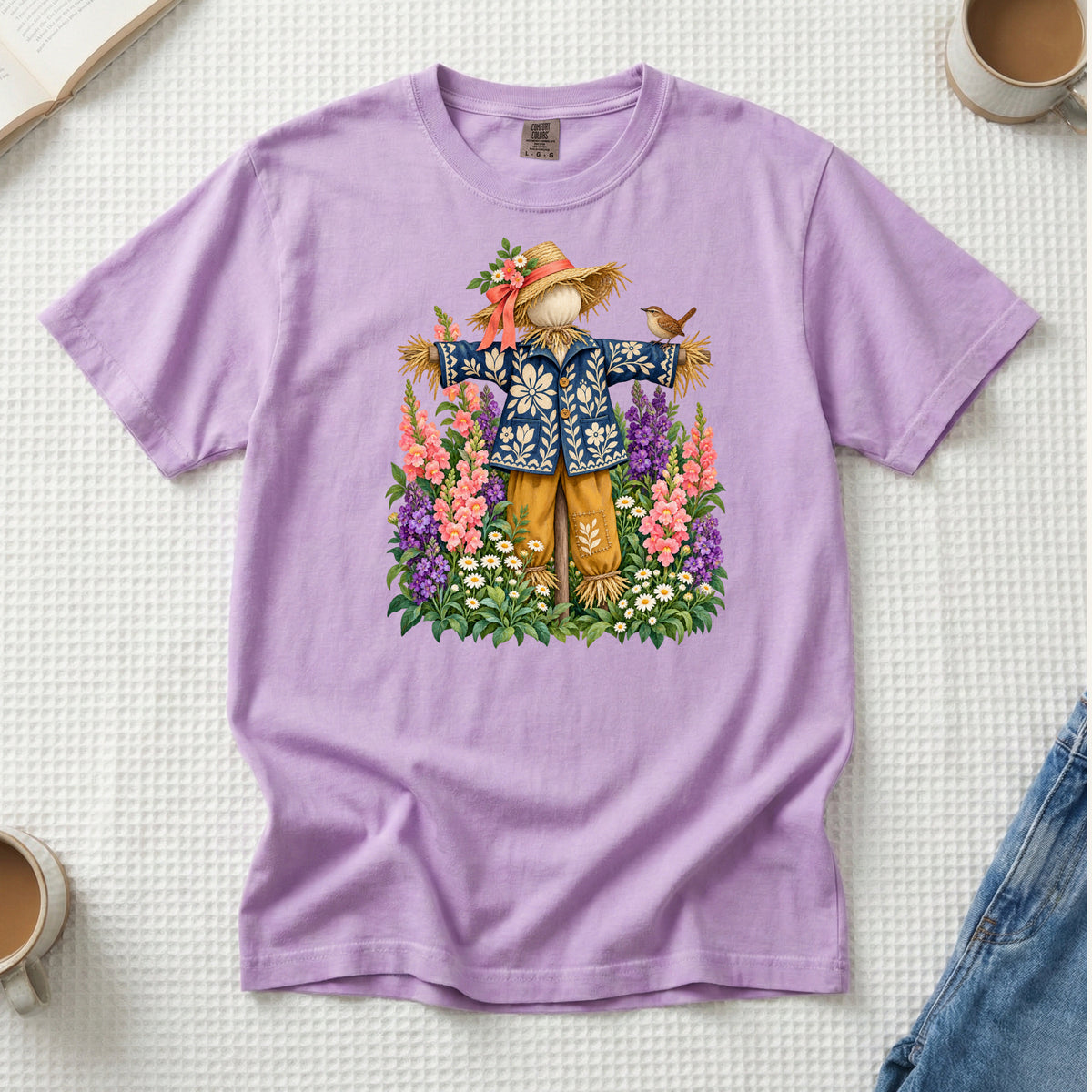 He Let Them Stay T-Shirt in Orchid — a gentle purple picking up the tall garden flowers