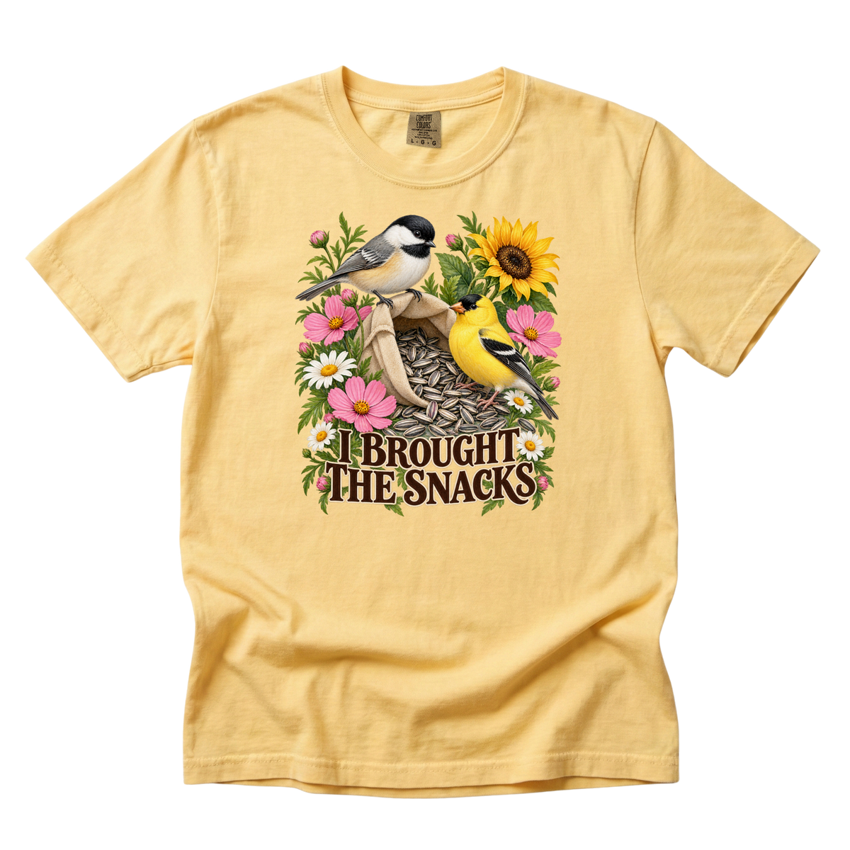 I Brought the Snacks tee in Butter, a goldfinch and chickadee with sunflower seeds and daisies