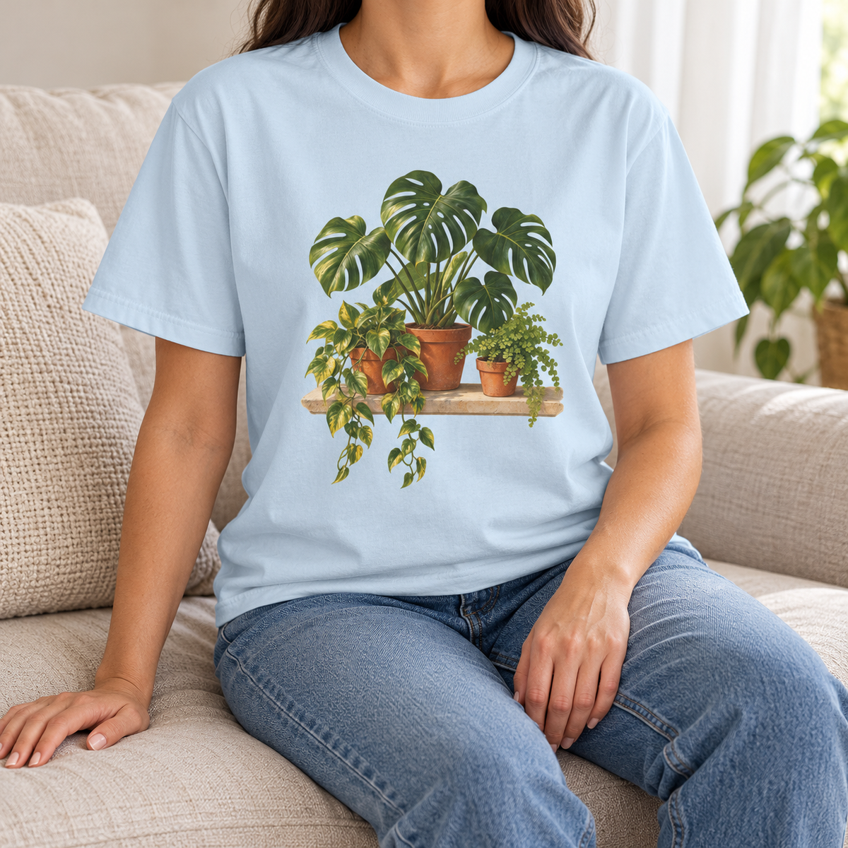 Houseplant t-shirt in Chambray – a woman seated in the pale icy-blue Comfort Colors tee with the potted botanical print