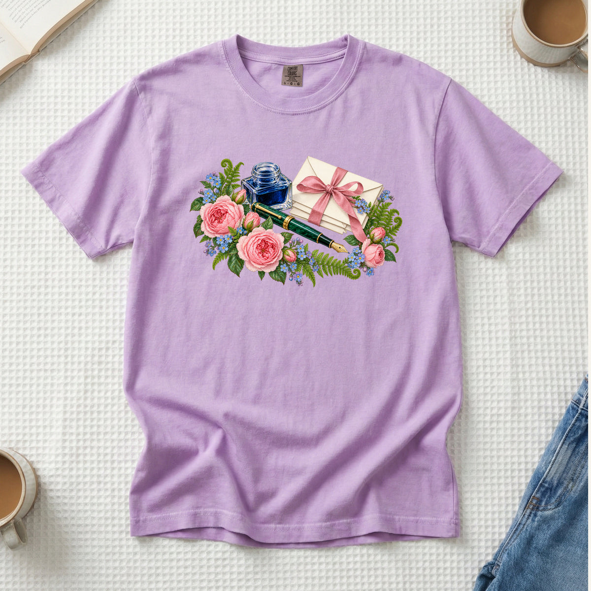 In Your Handwriting tee in Orchid, tied letters and pink roses on soft lilac, a gift for writers