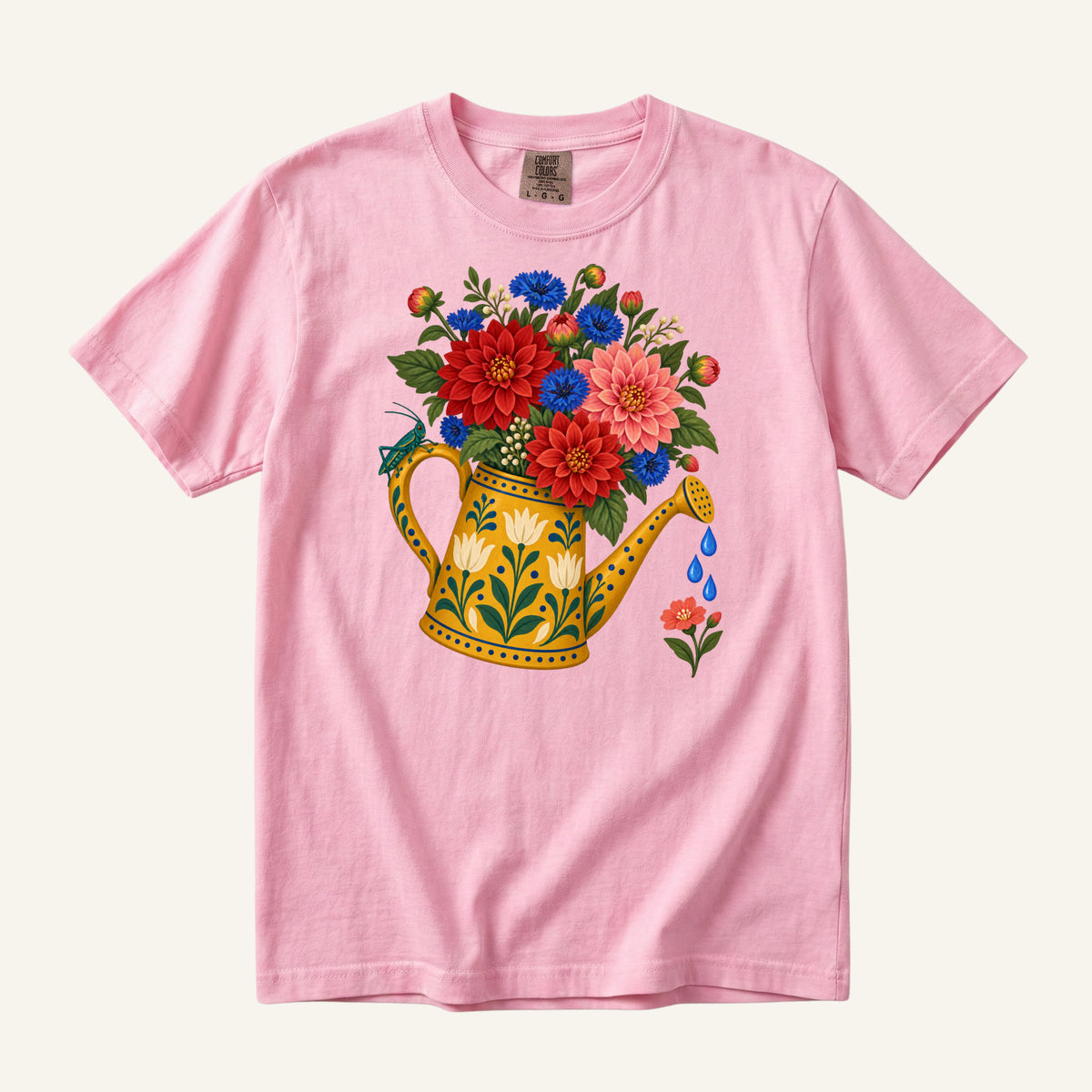 It Started With One Pot T-Shirt in Blossom — a soft pink emphasizing the golden can and blue accents