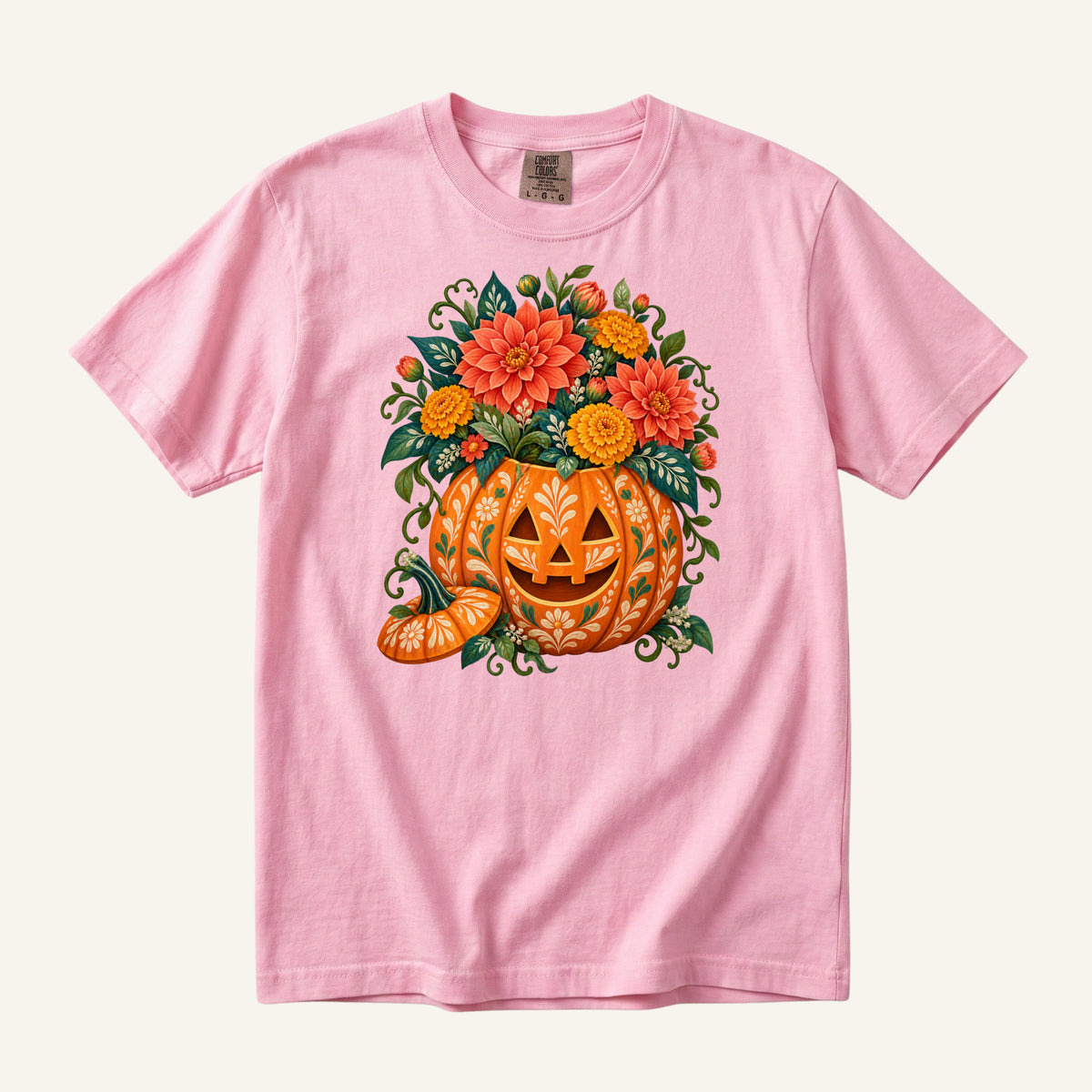 Floral jack-o'-lantern filled with coral and golden flowers on a Blossom pink Comfort Colors t-shirt