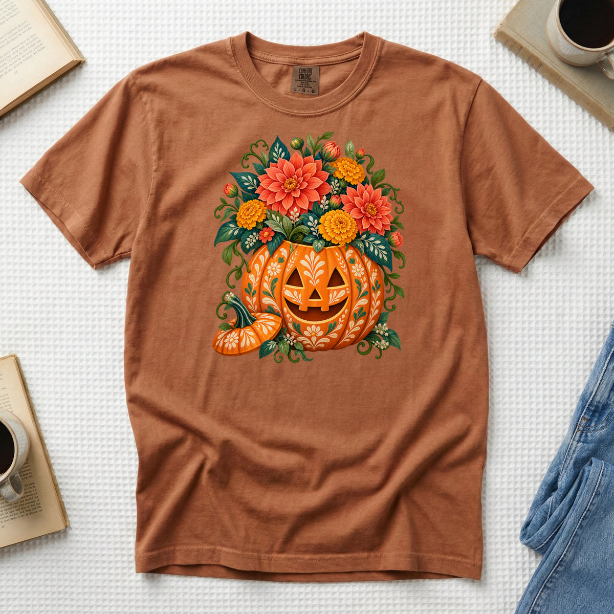 Floral jack-o'-lantern filled with coral and golden flowers on a Yam orange Comfort Colors t-shirt