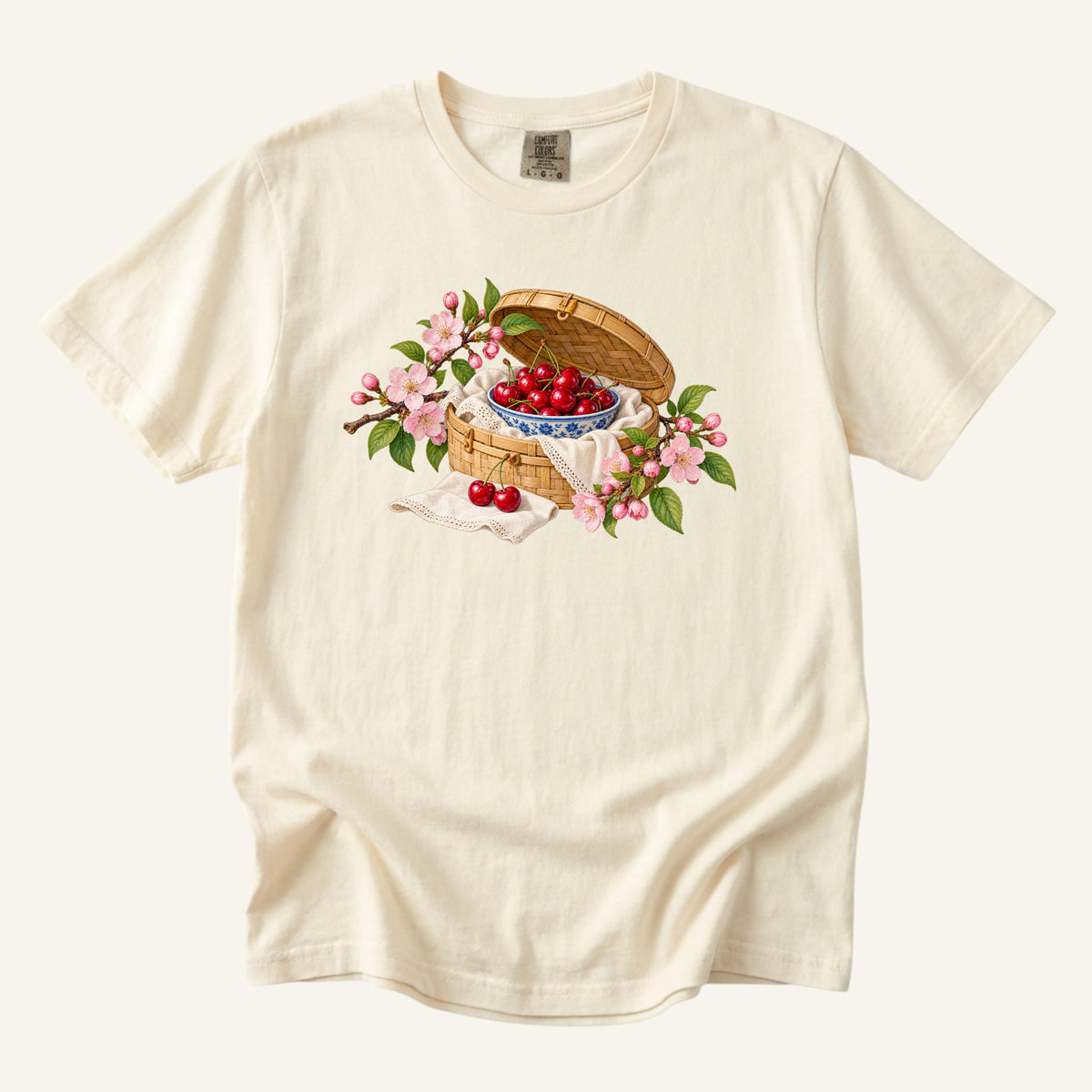 Leave the Afternoon Open tee in Ivory, a picnic basket with a blue-and-white bowl of cherries and pink blossoms