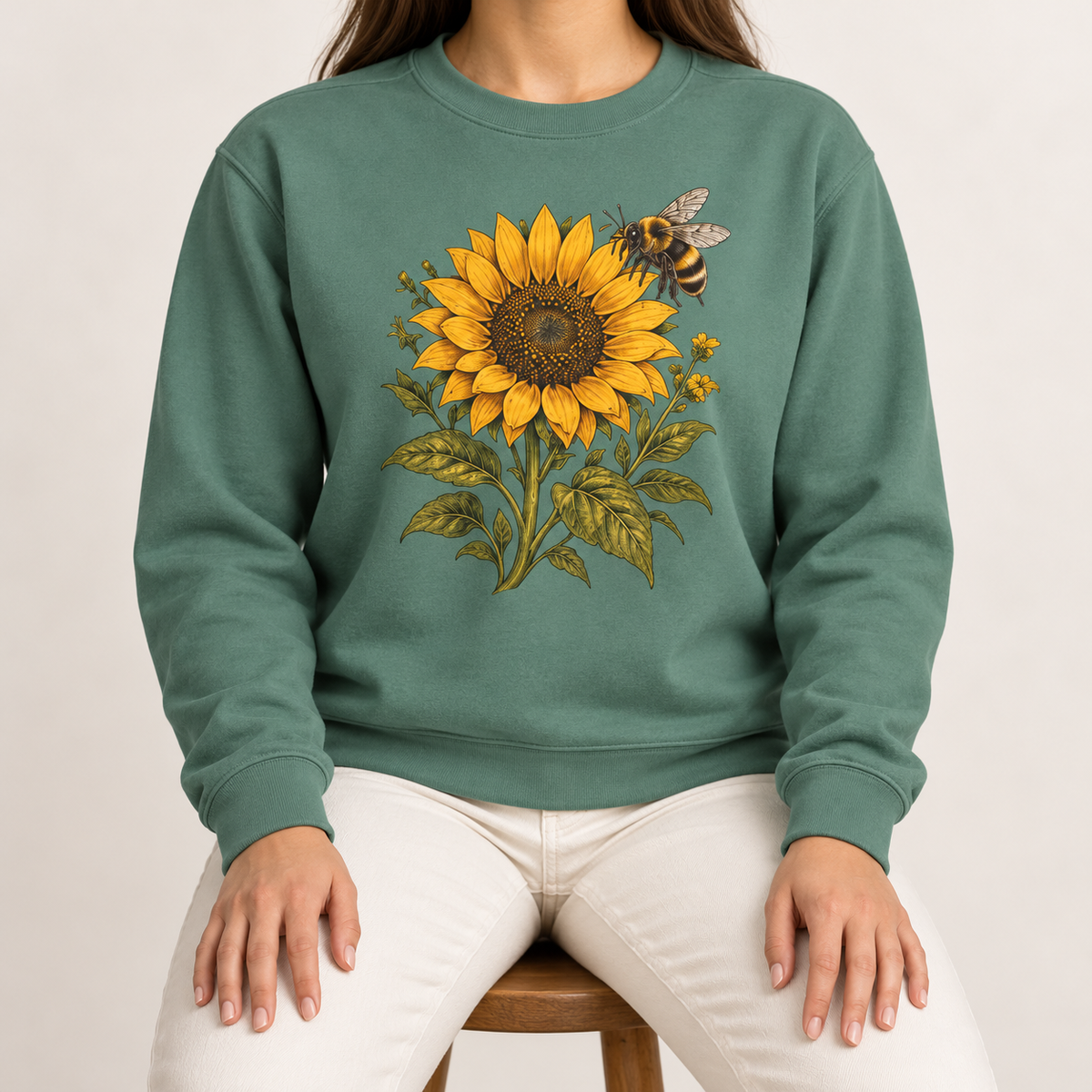 Sunflower and bumblebee sweatshirt in Light Green: a golden sunflower with a hovering bumblebee and olive leaves, on a soft sage garment-dyed Comfort Colors crewneck