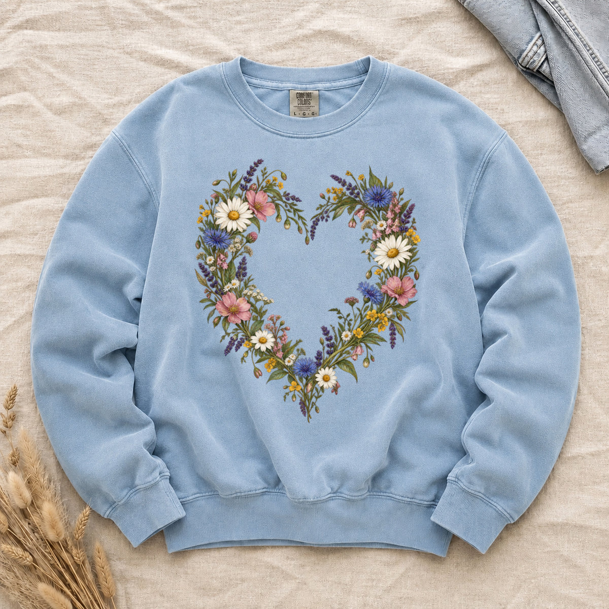 Love Grows Here sweatshirt in Chambray, a heart woven from white daisies, blue blooms and pink wildflowers
