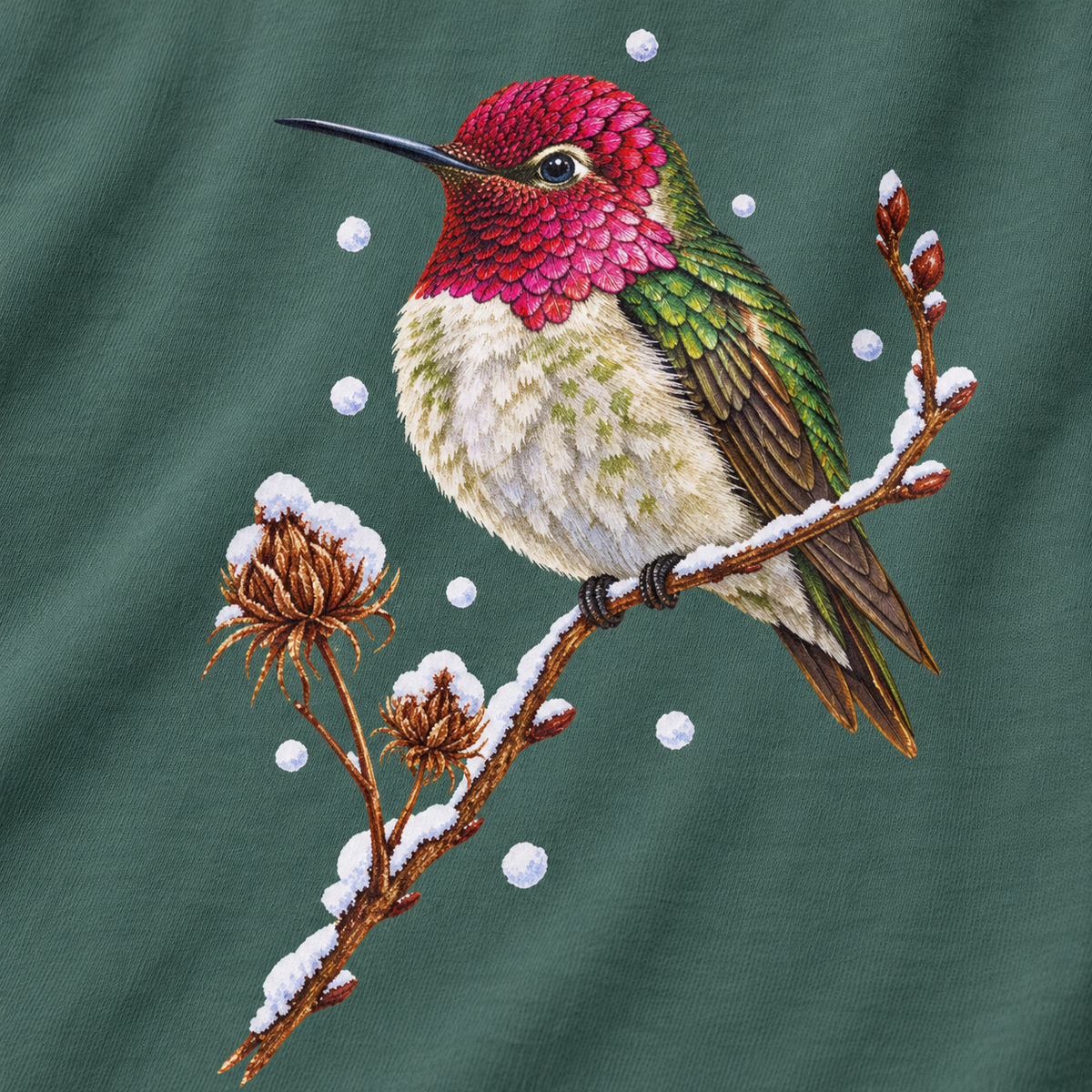 Close-up of the winter hummingbird print on a Blue Spruce Comfort Colors cotton tee - magenta crown and throat, emerald back, snowy twig and seed heads