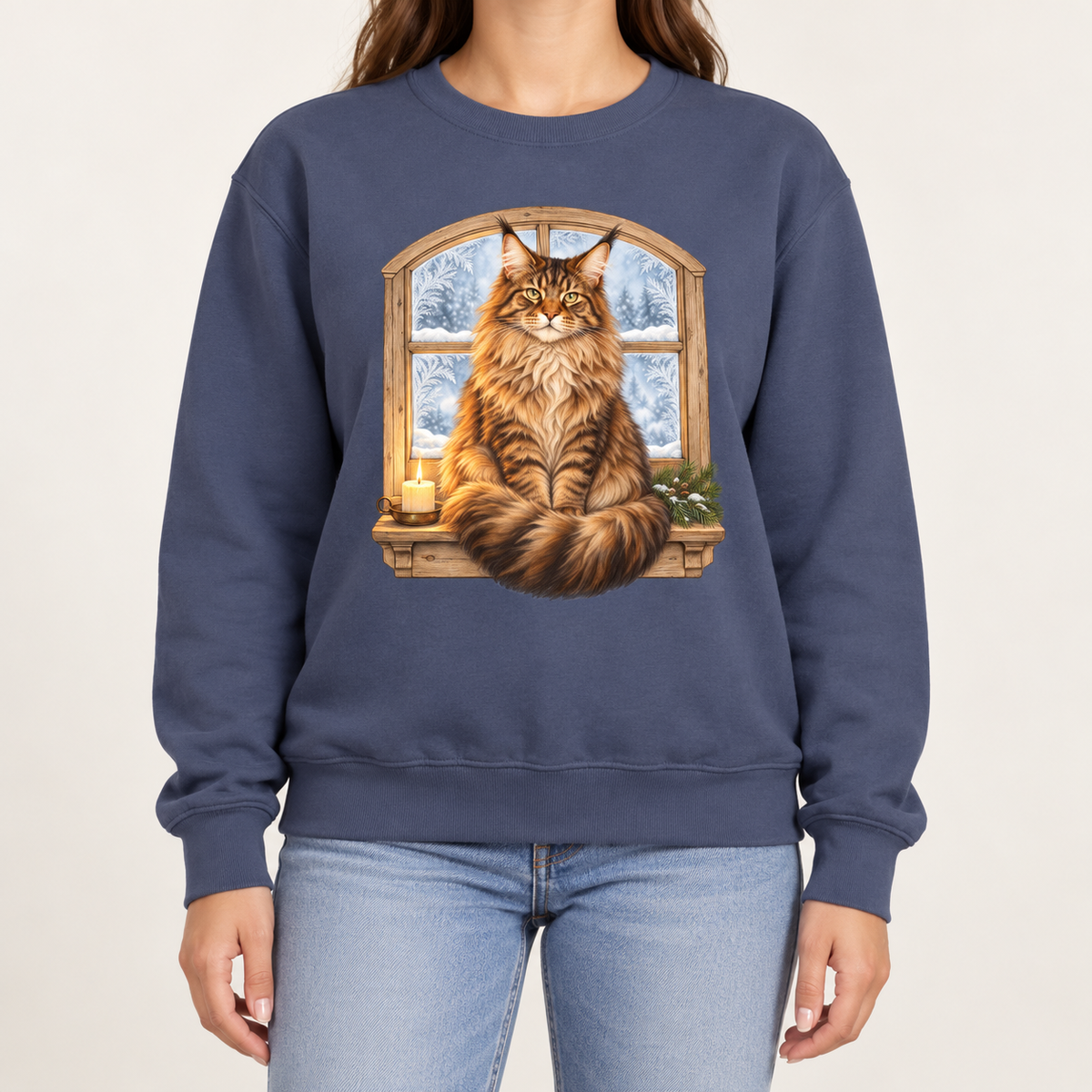 Maine Coon at the window sweatshirt – a tabby Maine Coon on a frosted windowsill with a candle and pine, snowy forest through an arched window, printed large on the chest of a Comfort Colors crewneck