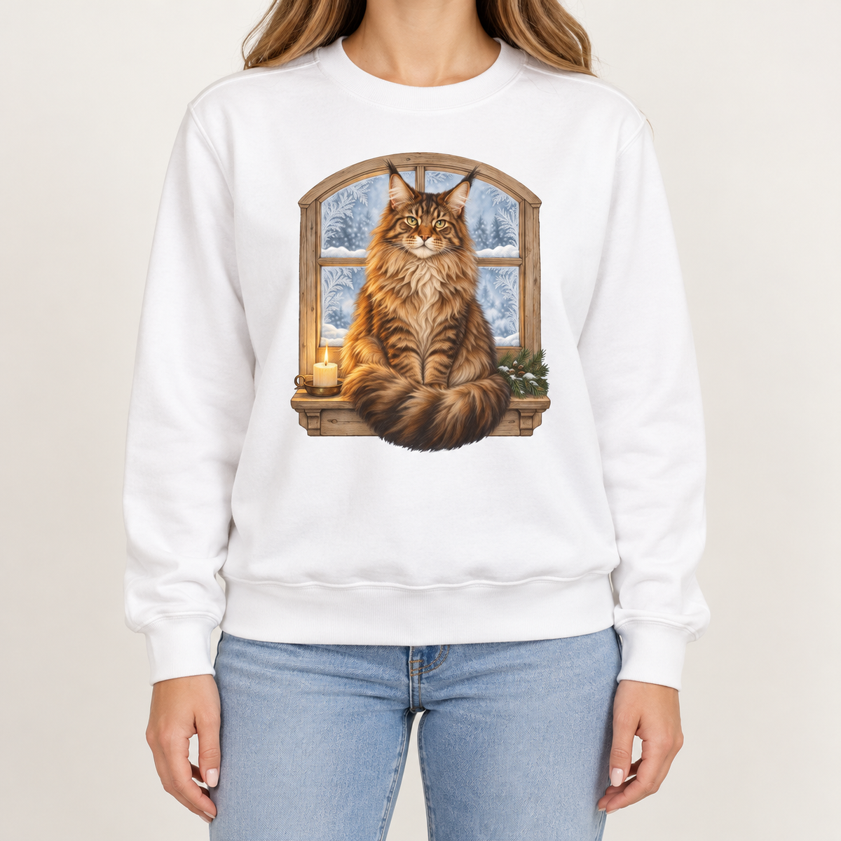 Maine Coon at the window sweatshirt – a tabby Maine Coon on a frosted windowsill with a candle and pine, snowy forest through an arched window, printed large on the chest of a Comfort Colors crewneck