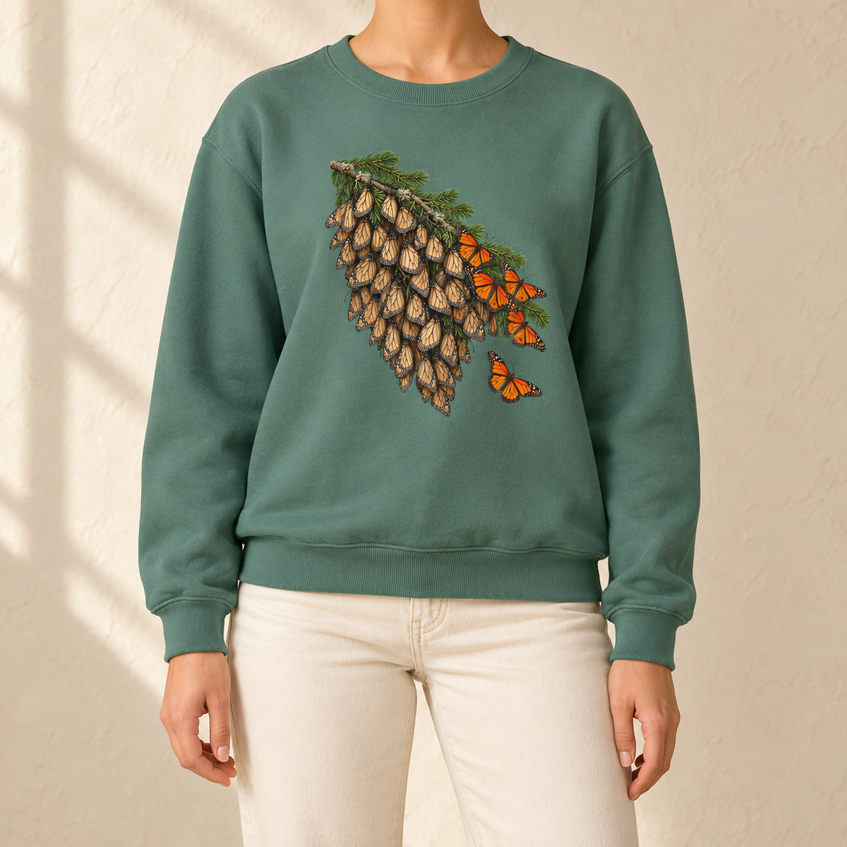 Overwintering Monarchs Sweatshirt in Light Green - a watercolor roost of monarch butterflies on a fir bough, wings closed, a few open in the sun, printed on a garment-dyed Comfort Colors 1566 crewneck