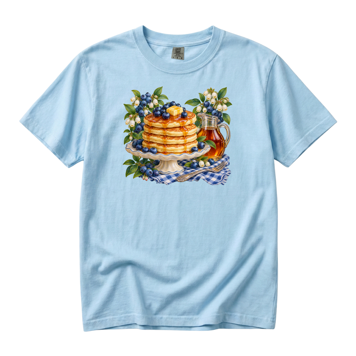 One More Pancake tee in Chambray, a stack of blueberry pancakes with butter, syrup pitcher and blossoms