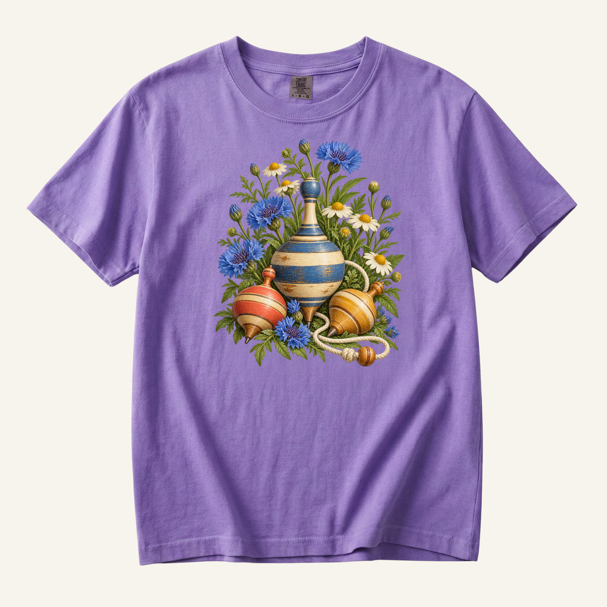 One More Spin T-Shirt in Violet — a playful pairing with the golden wooden tops