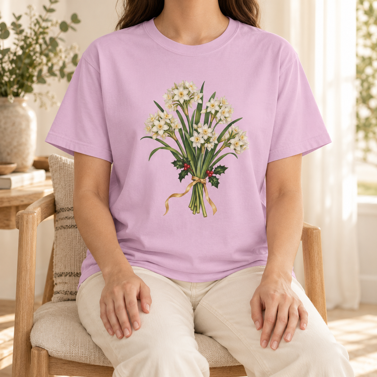 December birth flower t-shirt in Orchid – paperwhite and holly bouquet on a pale lavender-pink Comfort Colors tee, worn by a woman
