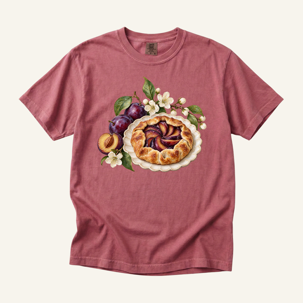 Saved You a Slice T-Shirt in Brick — a golden plum galette on a scalloped plate with purple plums and white blossoms