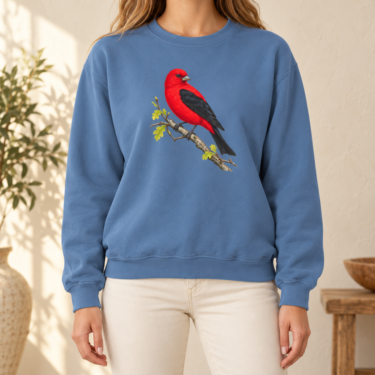 Scarlet Tanager sweatshirt in Blue Jean — a painted male scarlet tanager, red body with black wings, on an oak branch with new spring leaves, on a garment-dyed Comfort Colors crewneck