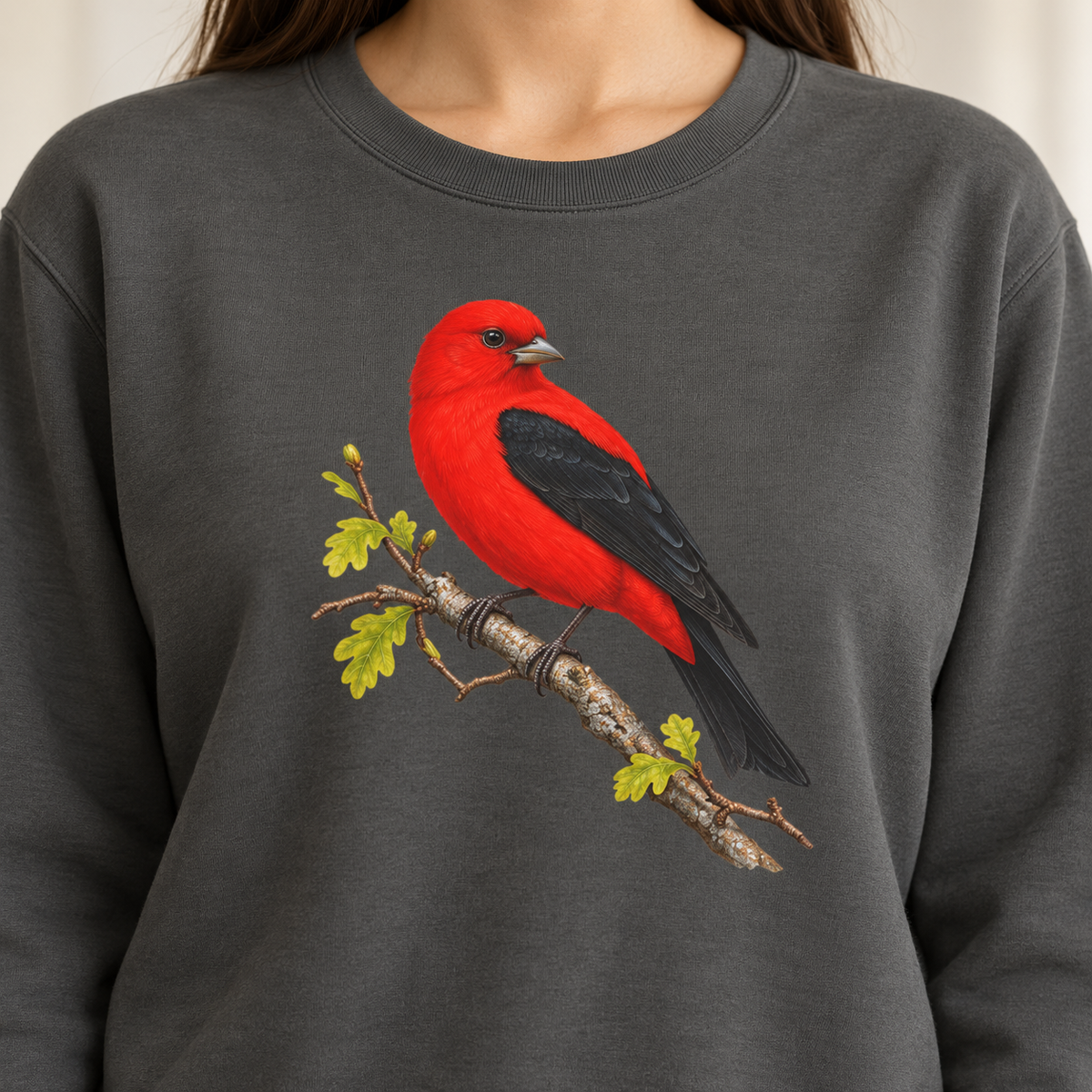 Close-up of the scarlet tanager print on a Pepper Comfort Colors crewneck — scarlet body, black wings, oak leaves