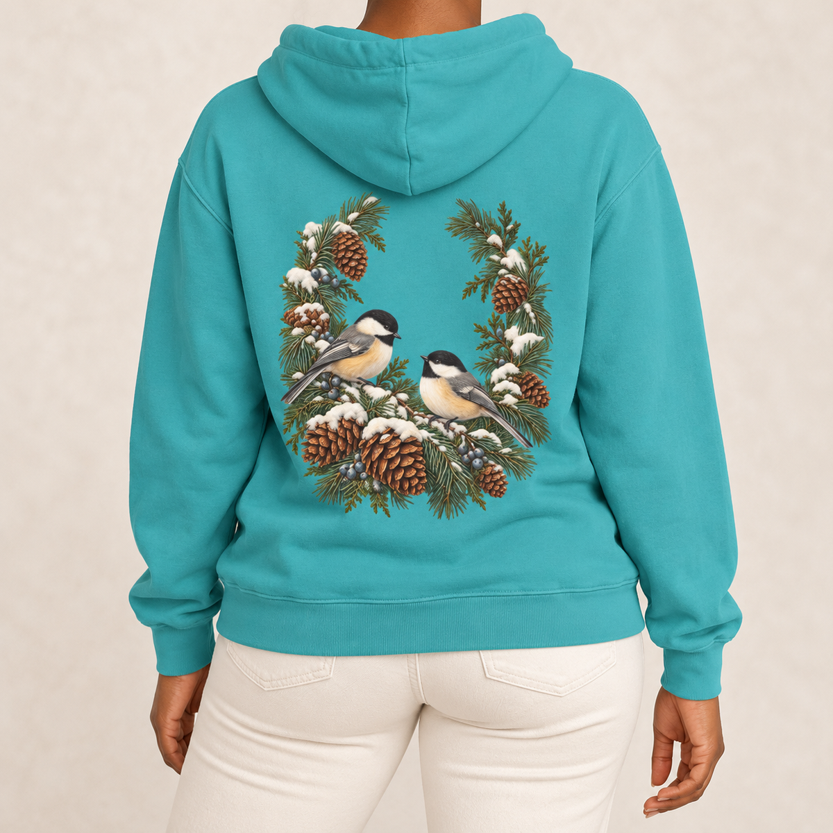 Winter Chickadee hoodie in Seafoam worn, back view with the chickadee and pinecone wreath