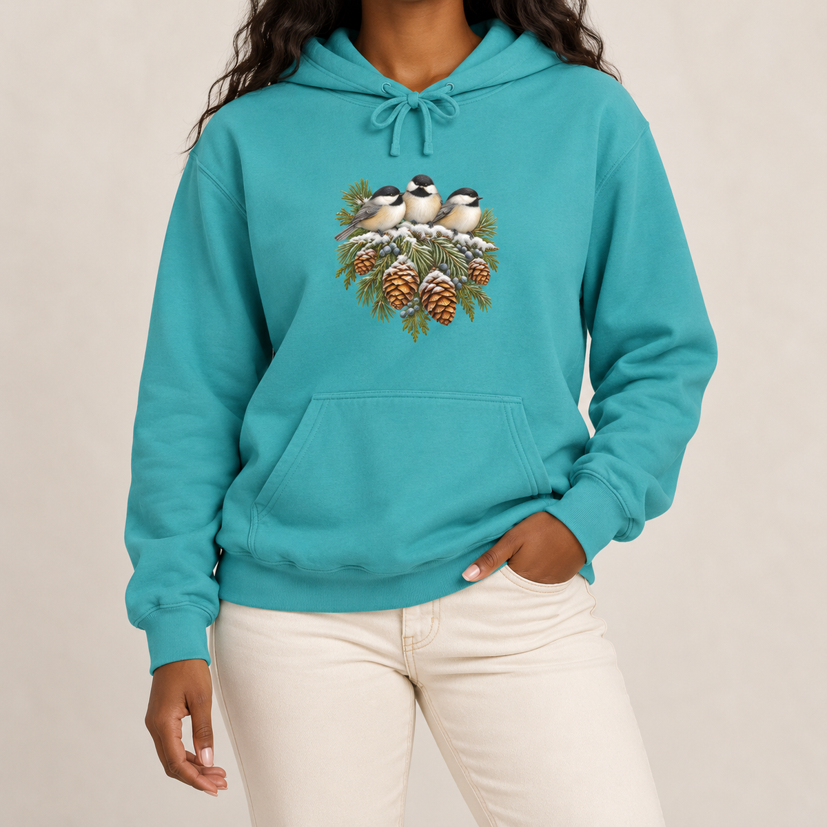 Winter Chickadee hoodie in Seafoam worn, front view with three chickadees on a snowy spruce bough