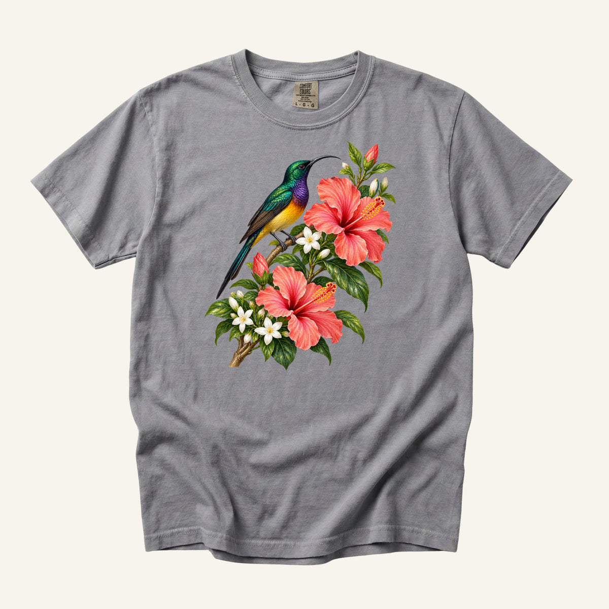Jewel-colored tropical bird beside coral hibiscus flowers and glossy green leaves, printed on a Grey Comfort Colors 1717 unisex t-shirt