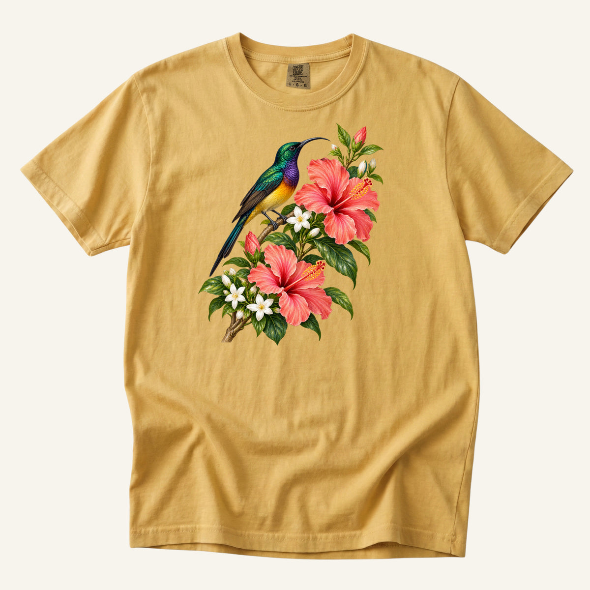 Jewel-colored tropical bird beside coral hibiscus flowers and glossy green leaves, printed on a Mustard yellow Comfort Colors 1717 unisex t-shirt