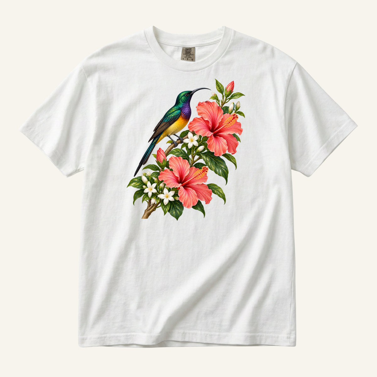 Jewel-colored tropical bird beside coral hibiscus flowers and glossy green leaves, printed on a white Comfort Colors 1717 unisex t-shirt