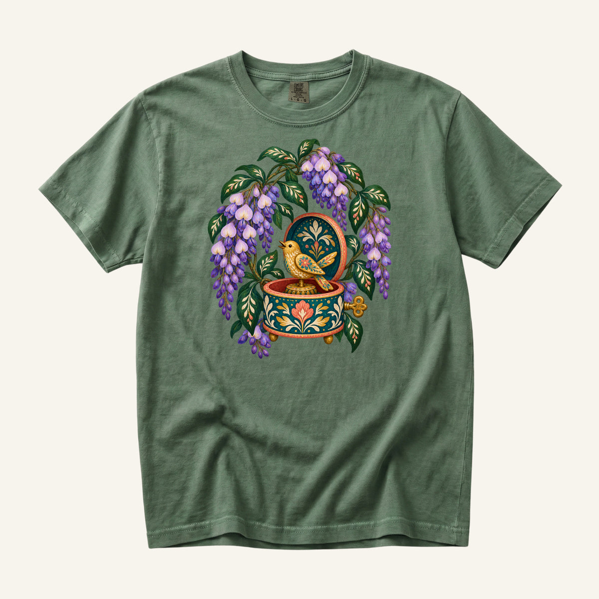 Folk-art music box with purple wisteria and a golden bird illustration on a Moss green Comfort Colors t-shirt
