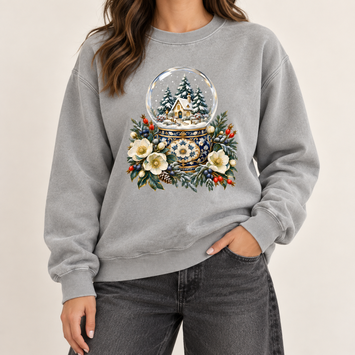 Snow globe and winter florals design on a heavyweight garment-dyed Comfort Colors 1566 crewneck — a glass snow globe holding a snowy cottage and evergreens on an ornate navy-and-gold base, framed by cream blossoms and red berries