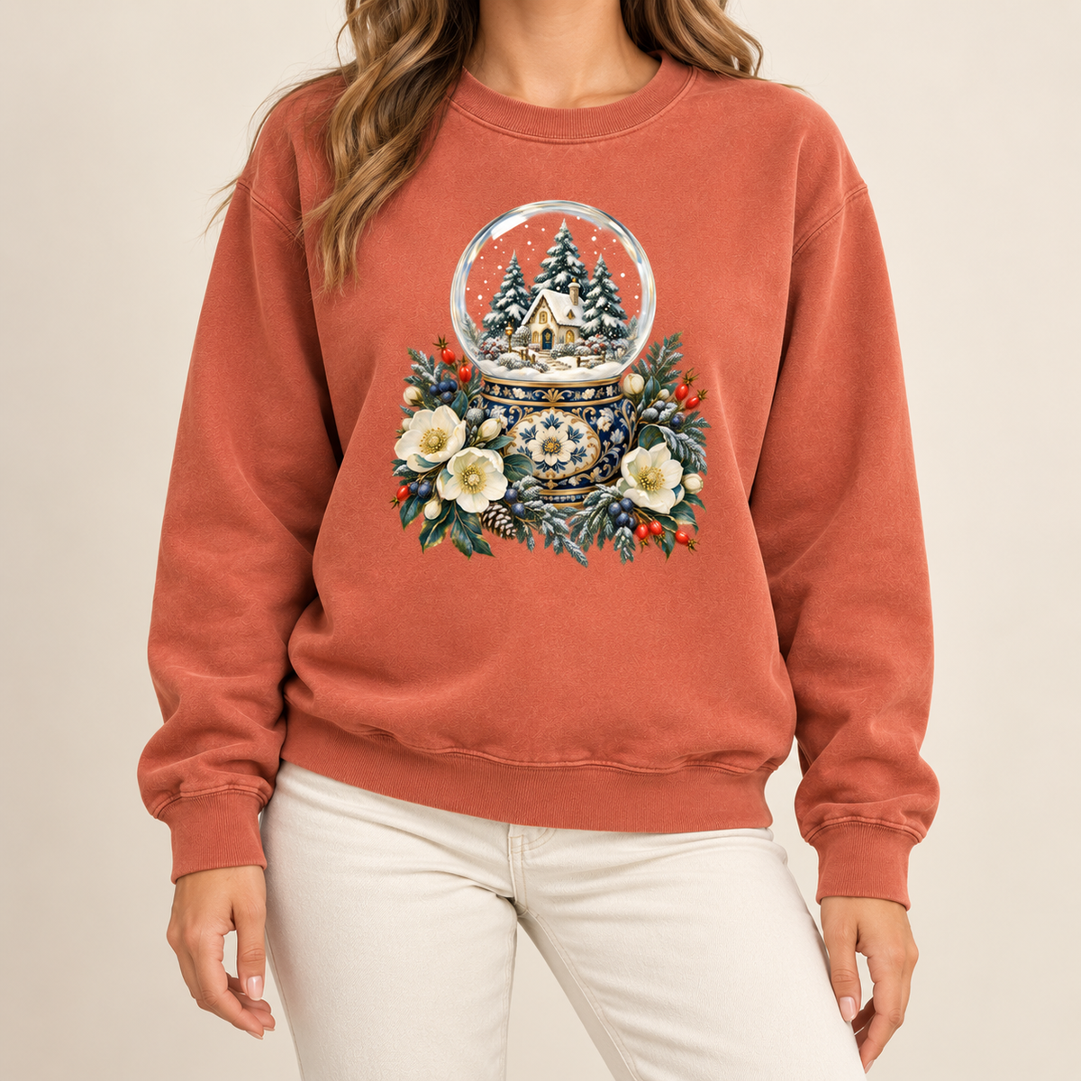 Snow globe and winter florals design on a side-seamed Comfort Colors 1566 crewneck — a glass snow globe holding a snowy cottage and evergreens on an ornate navy-and-gold base, framed by cream blossoms and red berries