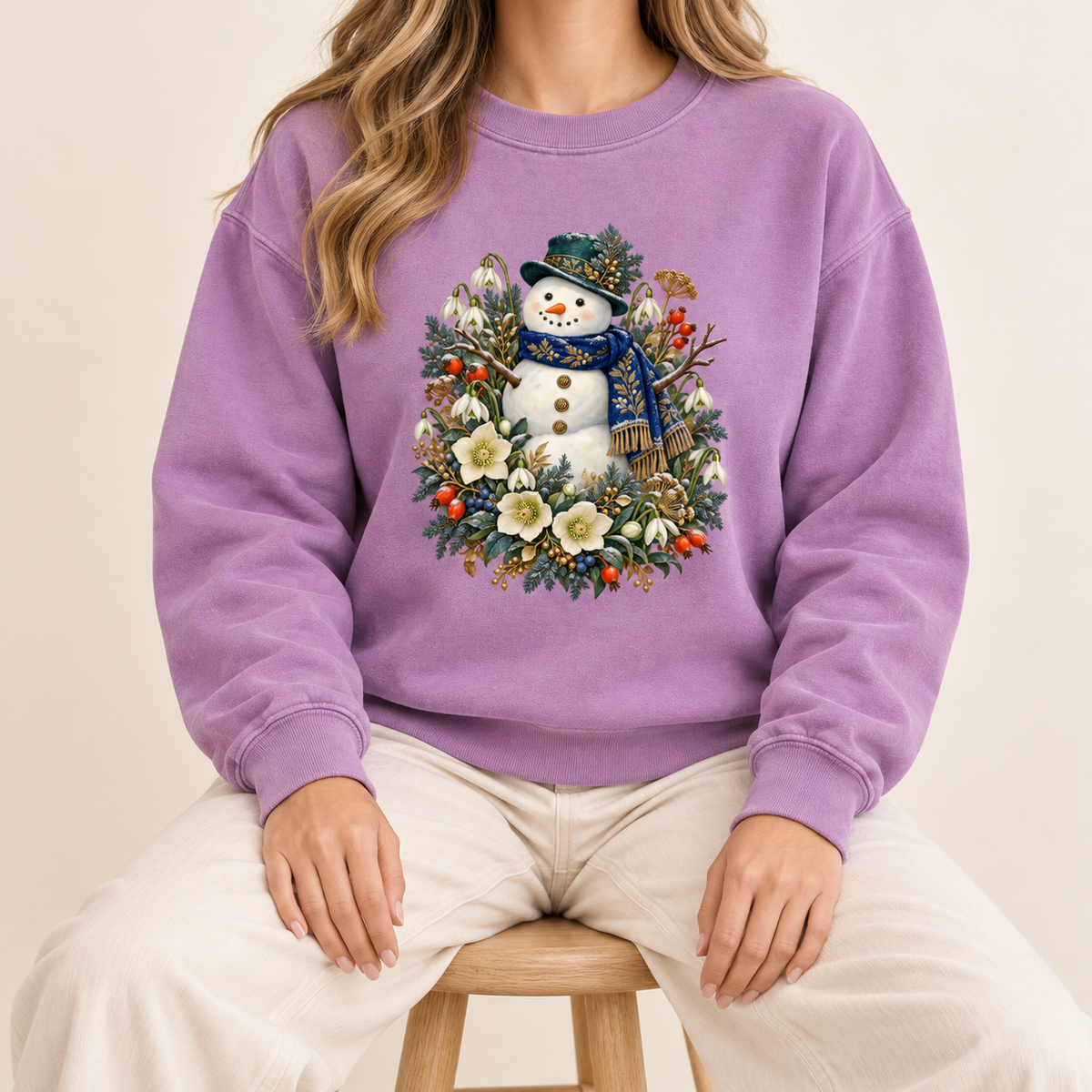 Snowman and winter botanicals sweatshirt, large front-centered print, no lettering — a smiling snowman in a dark hat and blue scarf among evergreen, red berries and cream flowers