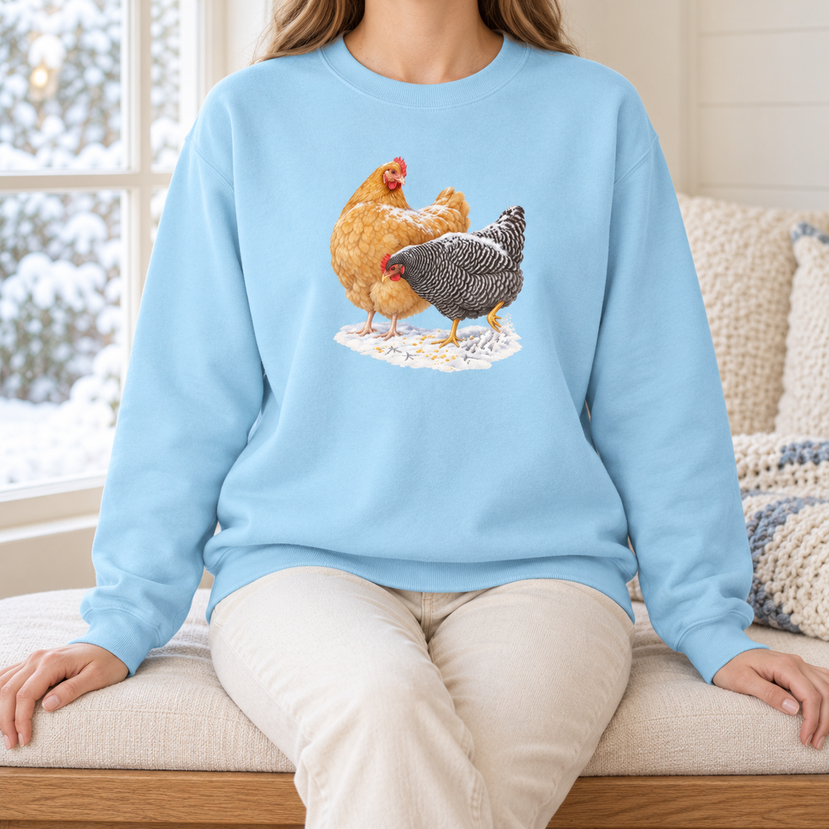 Winter hens sweatshirt in Chambray worn by a woman – two hens in the snow on the palest washed blue Comfort Colors crewneck