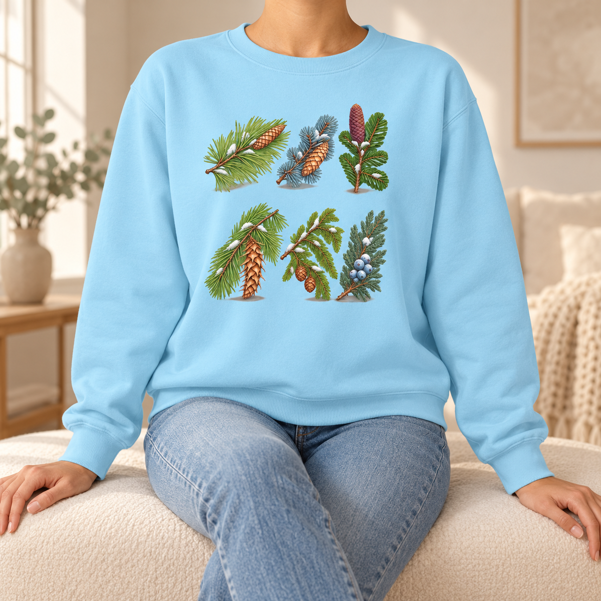 Evergreen Study Sweatshirt in Chambray, worn - six watercolor conifer sprigs with cones and snow on a garment-dyed Comfort Colors crewneck