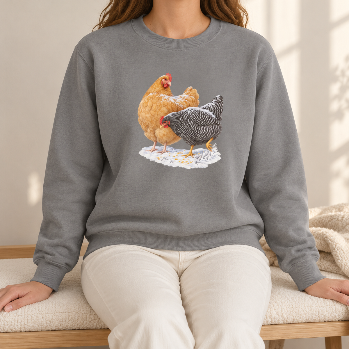 Winter hens sweatshirt in Grey worn by a woman – Buff Orpington and Barred Rock in snow on a soft heathered grey Comfort Colors crewneck