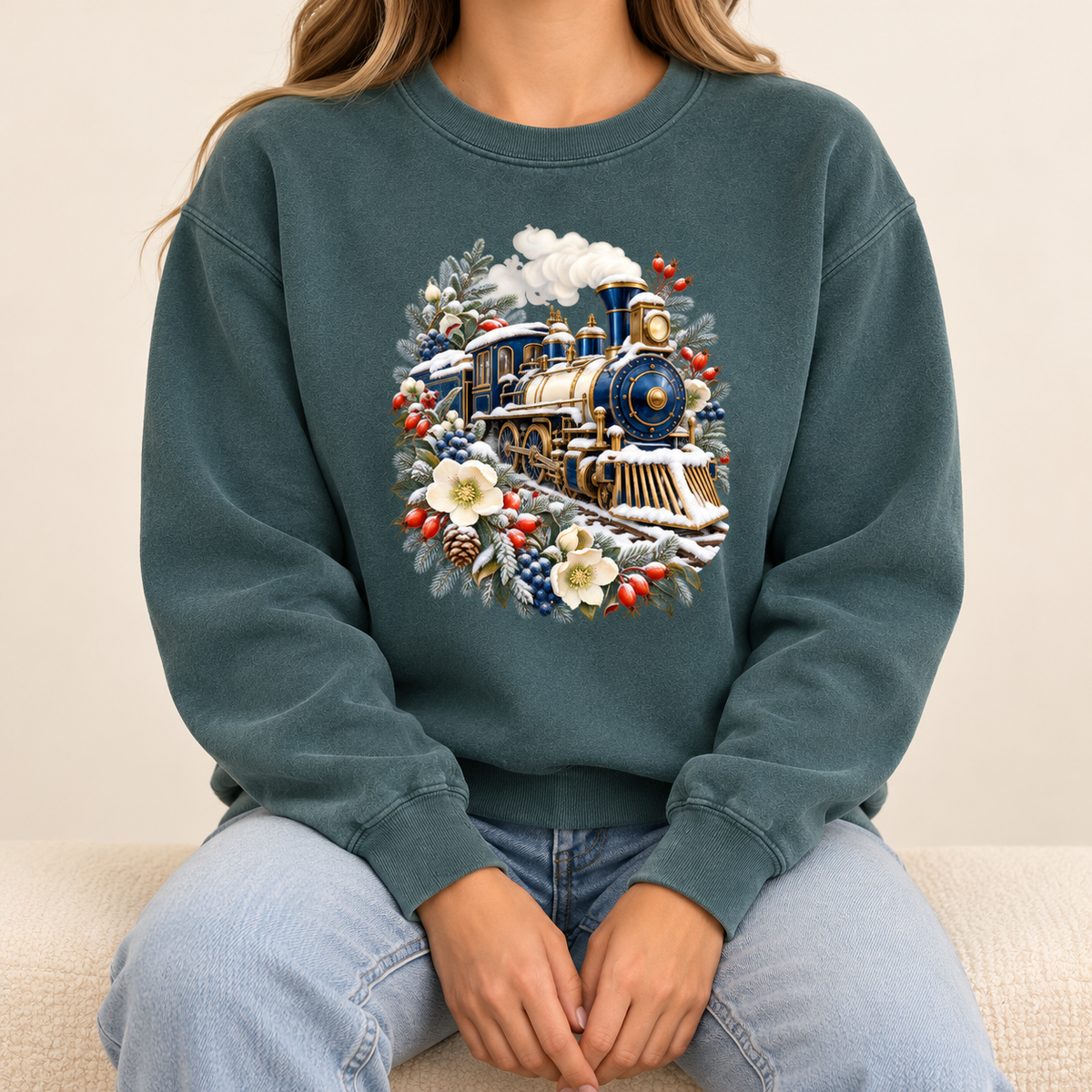 Steam train and winter botanicals design on a made-to-order Comfort Colors 1566 crewneck — a deep blue and gold steam locomotive ringed by snow-dusted evergreen, red berries, pinecones and cream flowers