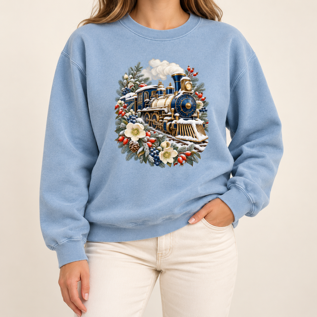 Steam train and winter botanicals design on a twill-taped, garment-dyed heavyweight crewneck — a deep blue and gold steam locomotive ringed by snow-dusted evergreen, red berries, pinecones and cream flowers