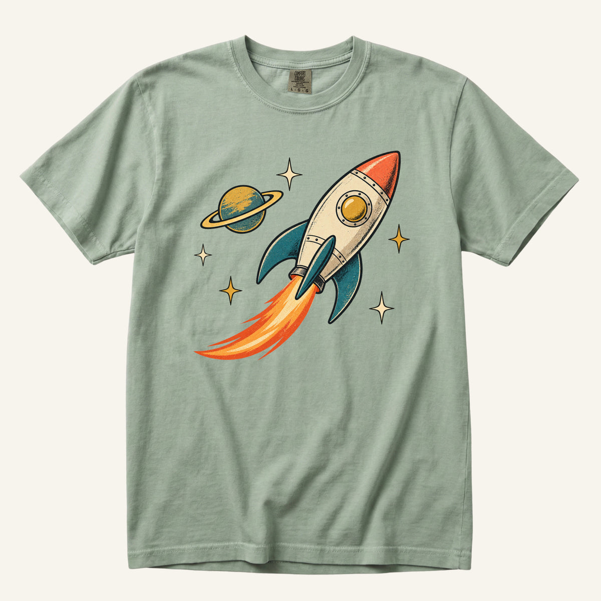 Still Looking Up T-Shirt in Bay — a cream-and-orange rocket with teal fins, a flame trail and a ringed planet