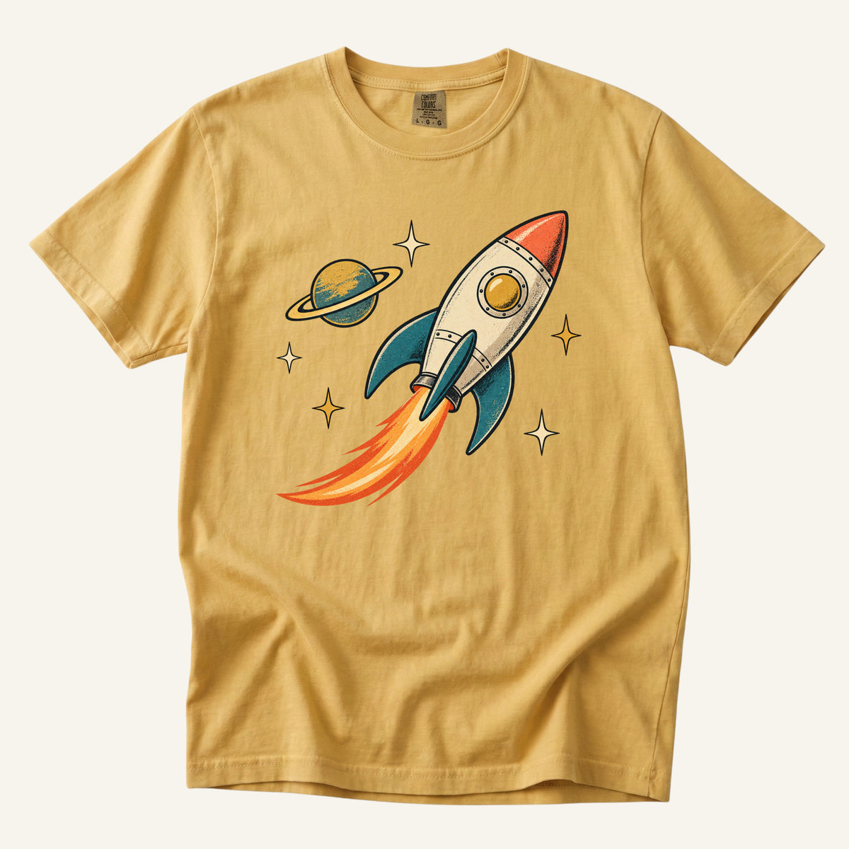 Still Looking Up T-Shirt in Mustard — warm gold emphasizing the orange flame and cream rocket