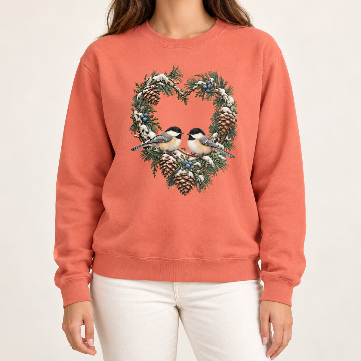 Chickadee heart wreath sweatshirt in Terracotta – a pair of chickadees on a snowy pine heart wreath with pinecones, printed large on the chest of a Comfort Colors crewneck