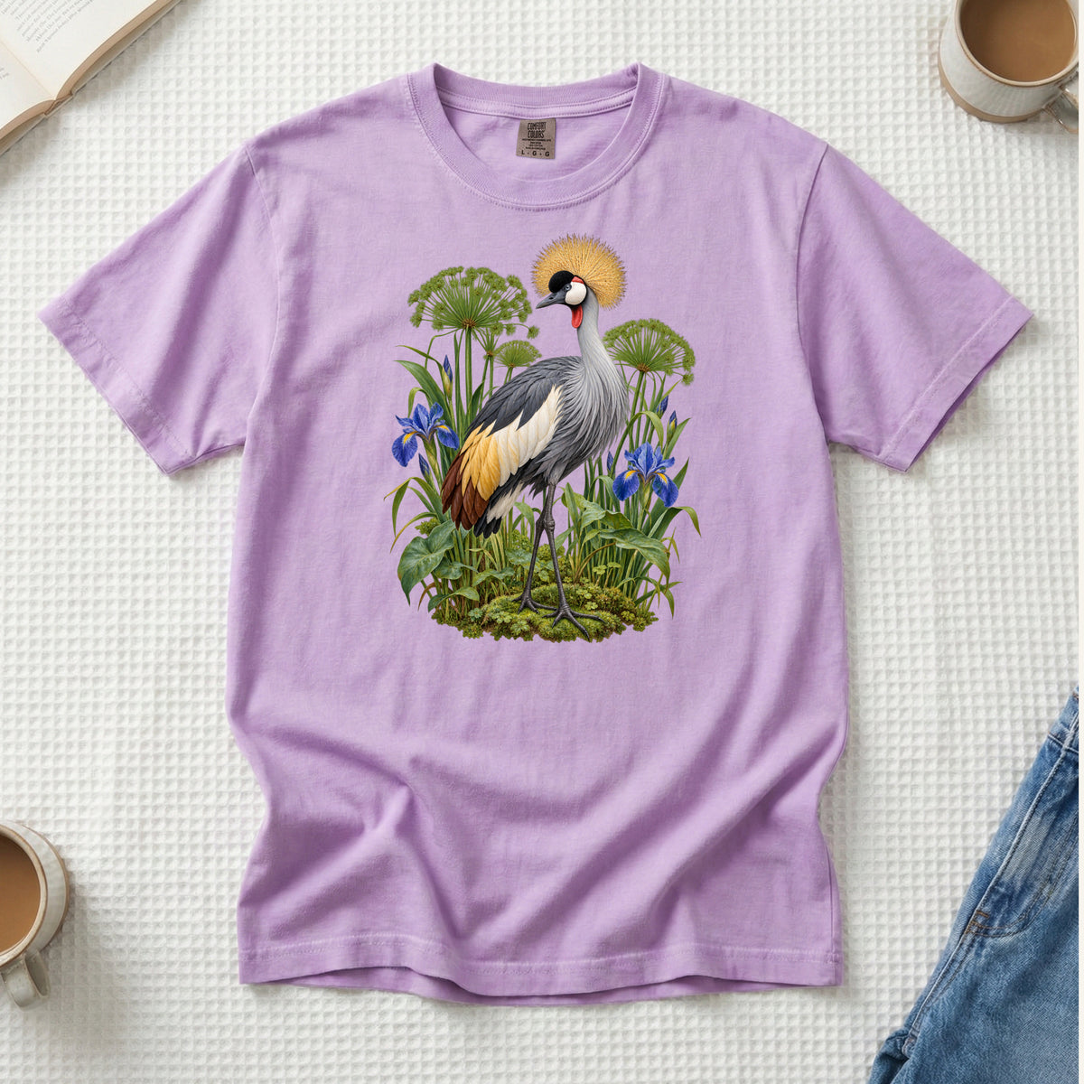 Crowned crane with a golden crest among blue irises and green stems, printed on an Orchid lavender Comfort Colors 1717 unisex t-shirt