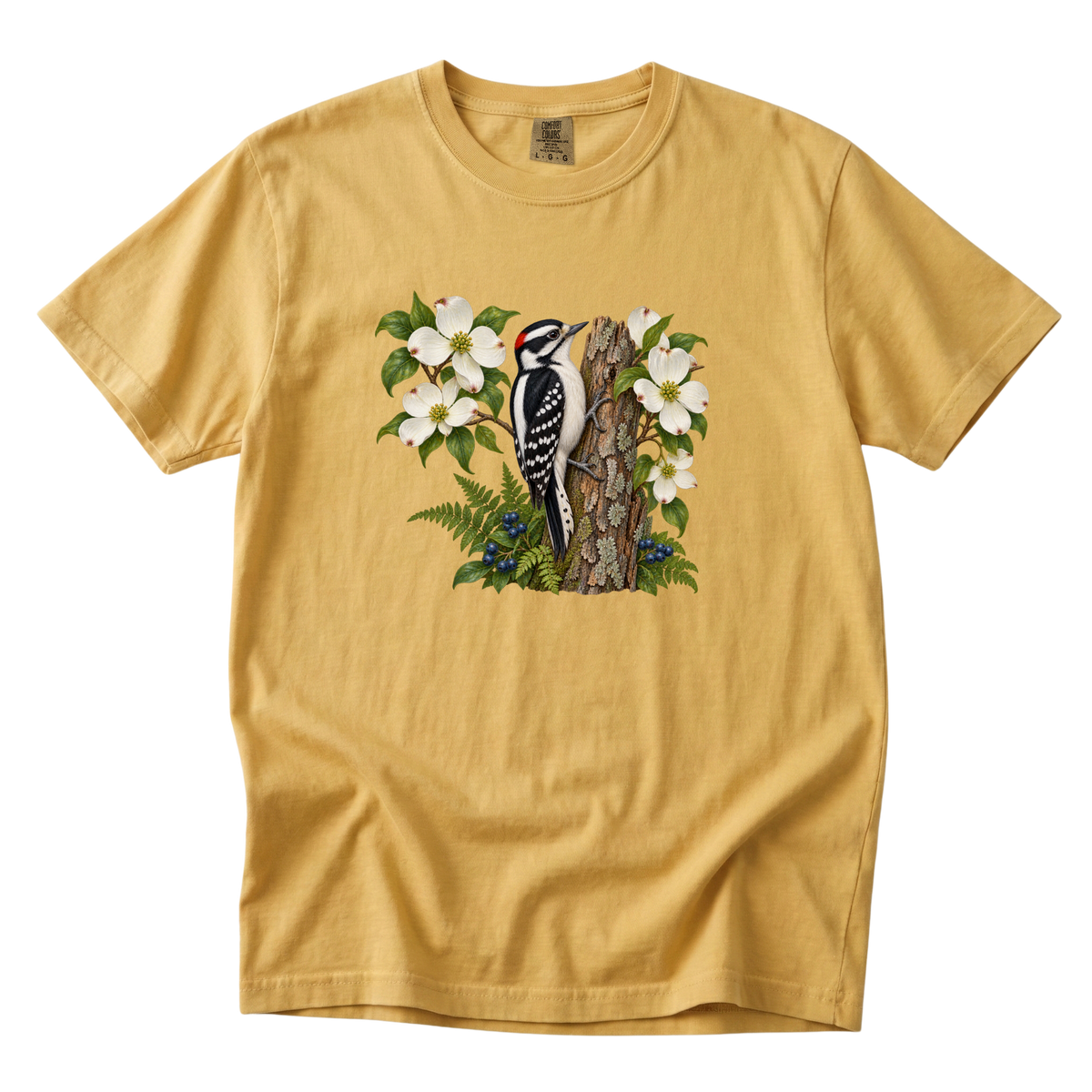 The Woods Have Rhythm woodpecker tee in Mustard, a woodpecker among white dogwood blossoms and ferns