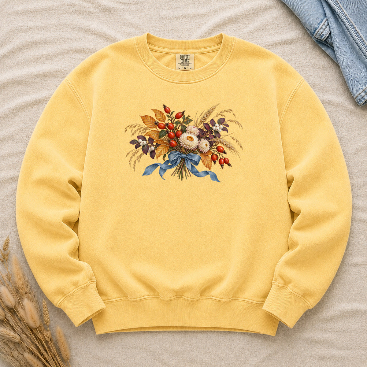 Tied to September sweatshirt in Butter, a harvest bouquet with a blue bow on soft yellow