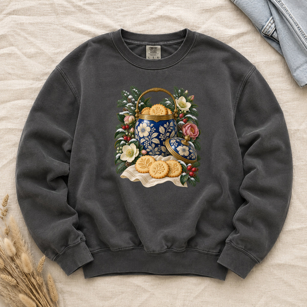 Vintage Cookie Jar and Winter Florals Sweatshirt in Pepper — a deep blue cookie jar patterned in cream and gold florals, open and full of golden cookies, among evergreen branches, red berries and pink and cream flowers