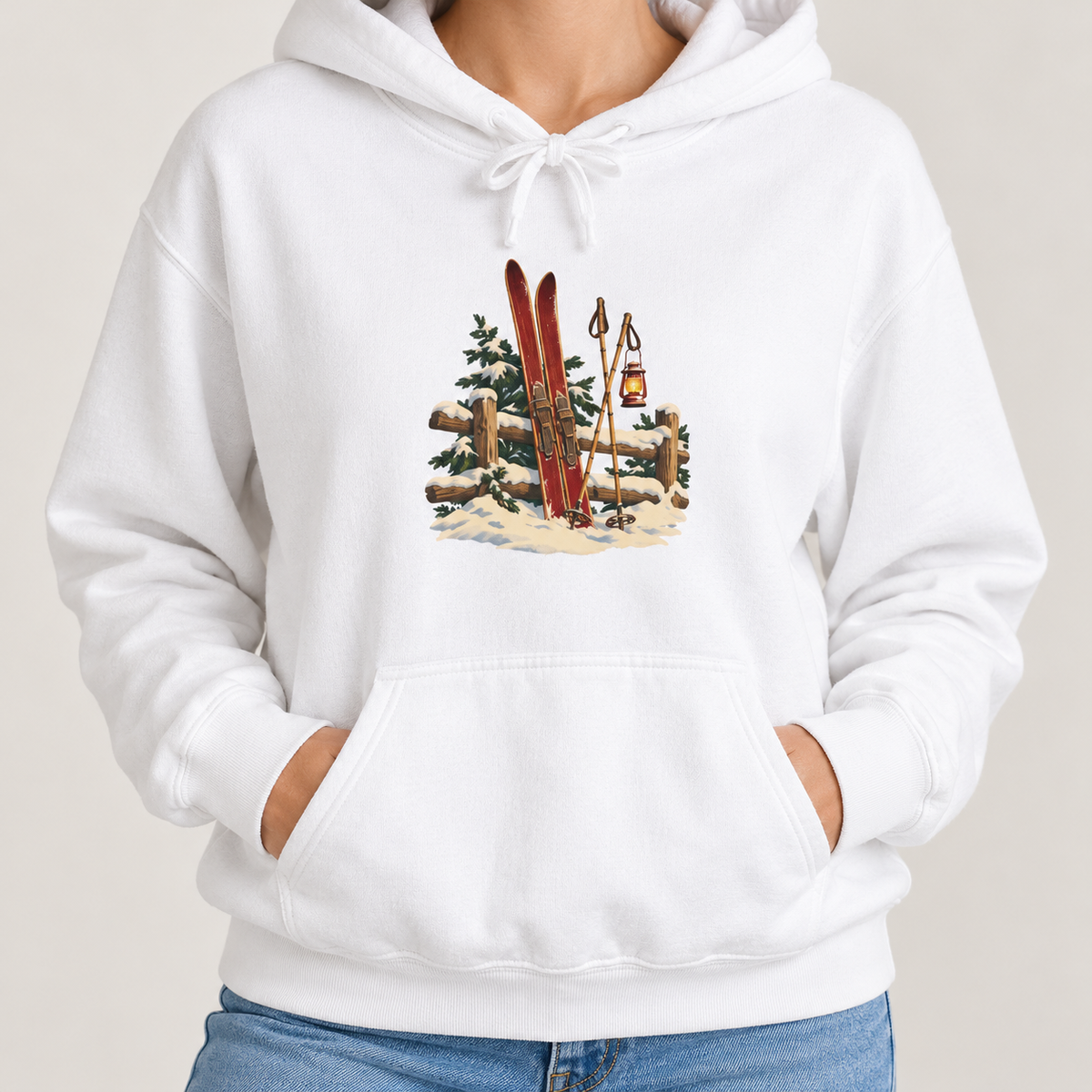 Vintage Ski Lodge hoodie in White worn by a woman, close view of the front print of red skis leaning on a snowy fence with a lantern