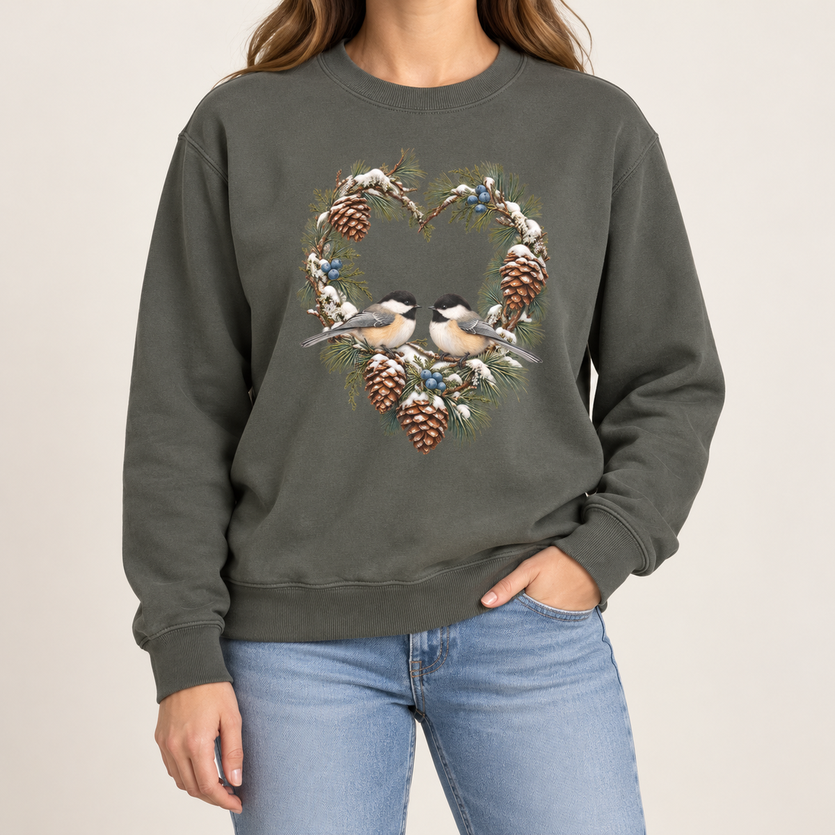 Chickadee heart wreath sweatshirt – a pair of chickadees on a snowy pine heart wreath with pinecones, printed large on the chest of a Comfort Colors crewneck