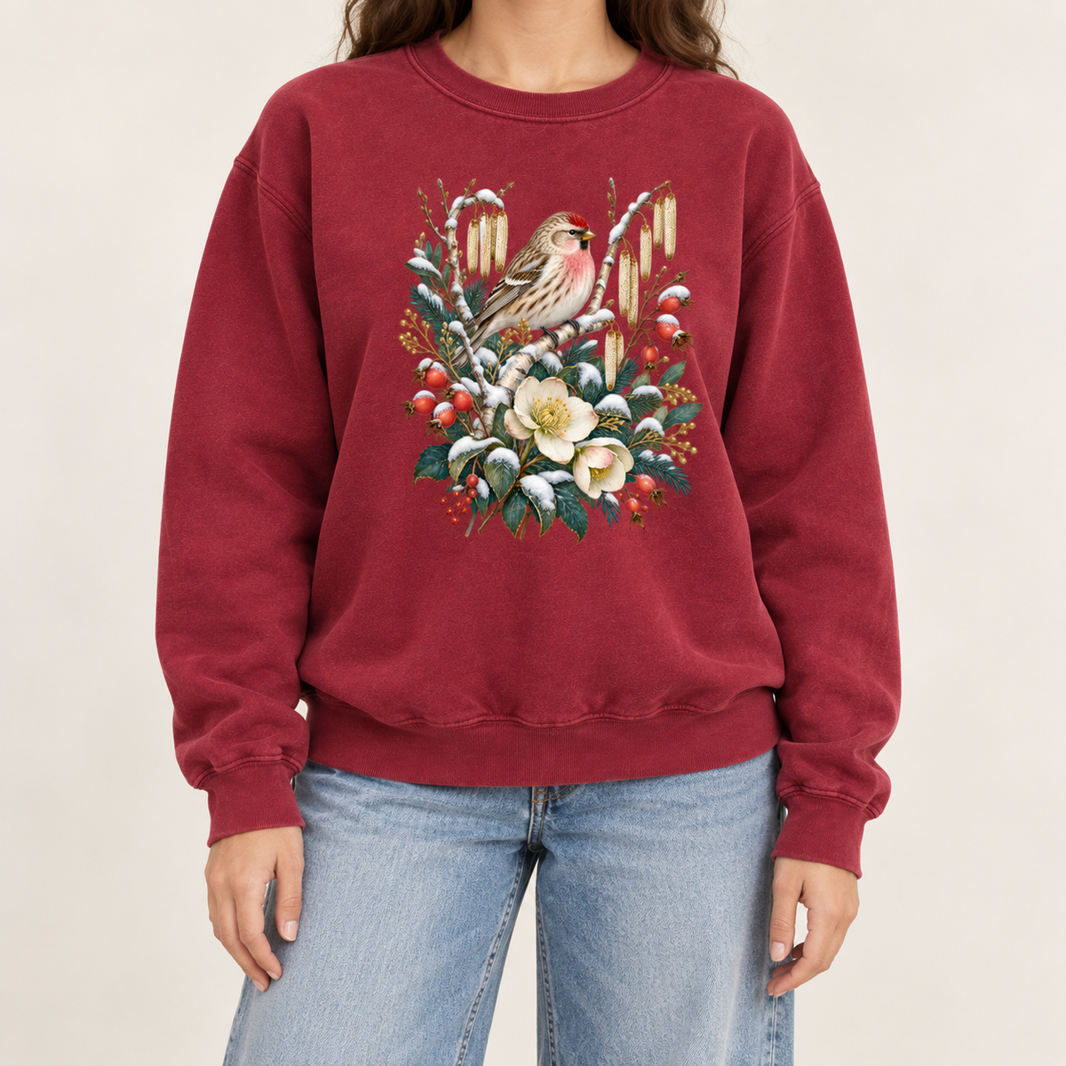 Winter finch and botanical design on a heavyweight garment-dyed Comfort Colors 1566 crewneck — a small brown finch with rosy red markings above snow-dusted evergreen, red berries and cream flowers