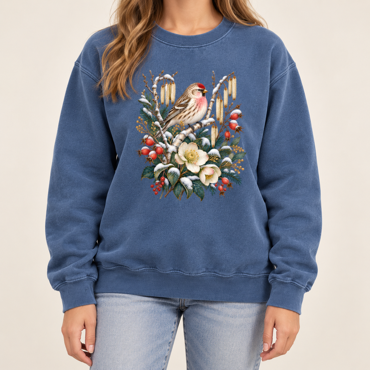 Winter finch design printed direct-to-garment on garment-dyed fleece — a small brown finch with rosy red markings above snow-dusted evergreen, red berries and cream flowers