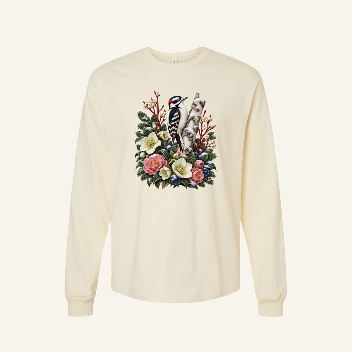 Woodpecker and Winter Florals Long Sleeve Tee in Natural — a black-and-white woodpecker with a small red patch at the back of its head, clinging to a pale birch trunk among evergreens, cream and pink flowers and winter berries