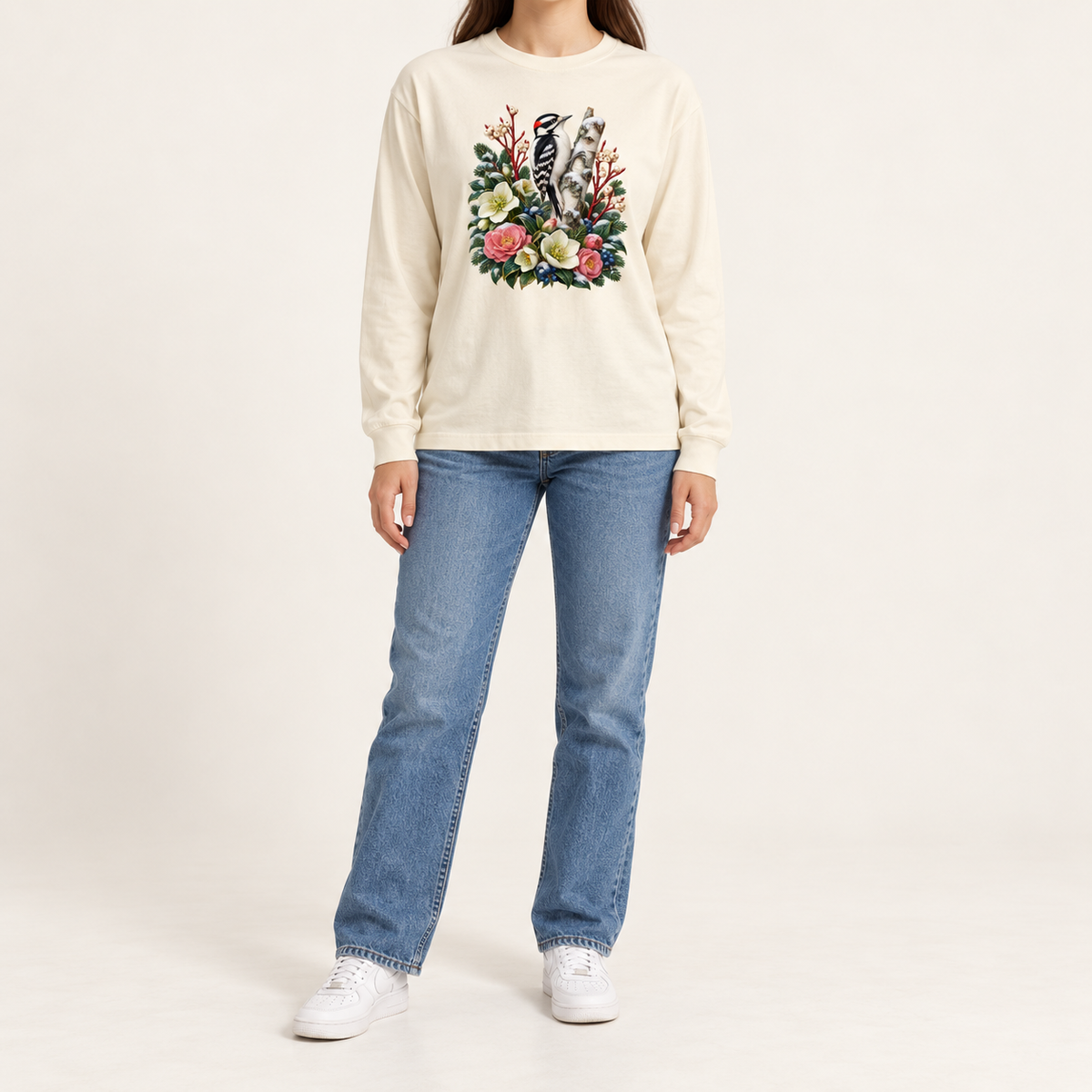 Woodpecker botanical graphic print on a heavyweight Bella+Canvas 3511 long sleeve tee — a black-and-white woodpecker on a pale birch trunk among evergreens and winter florals