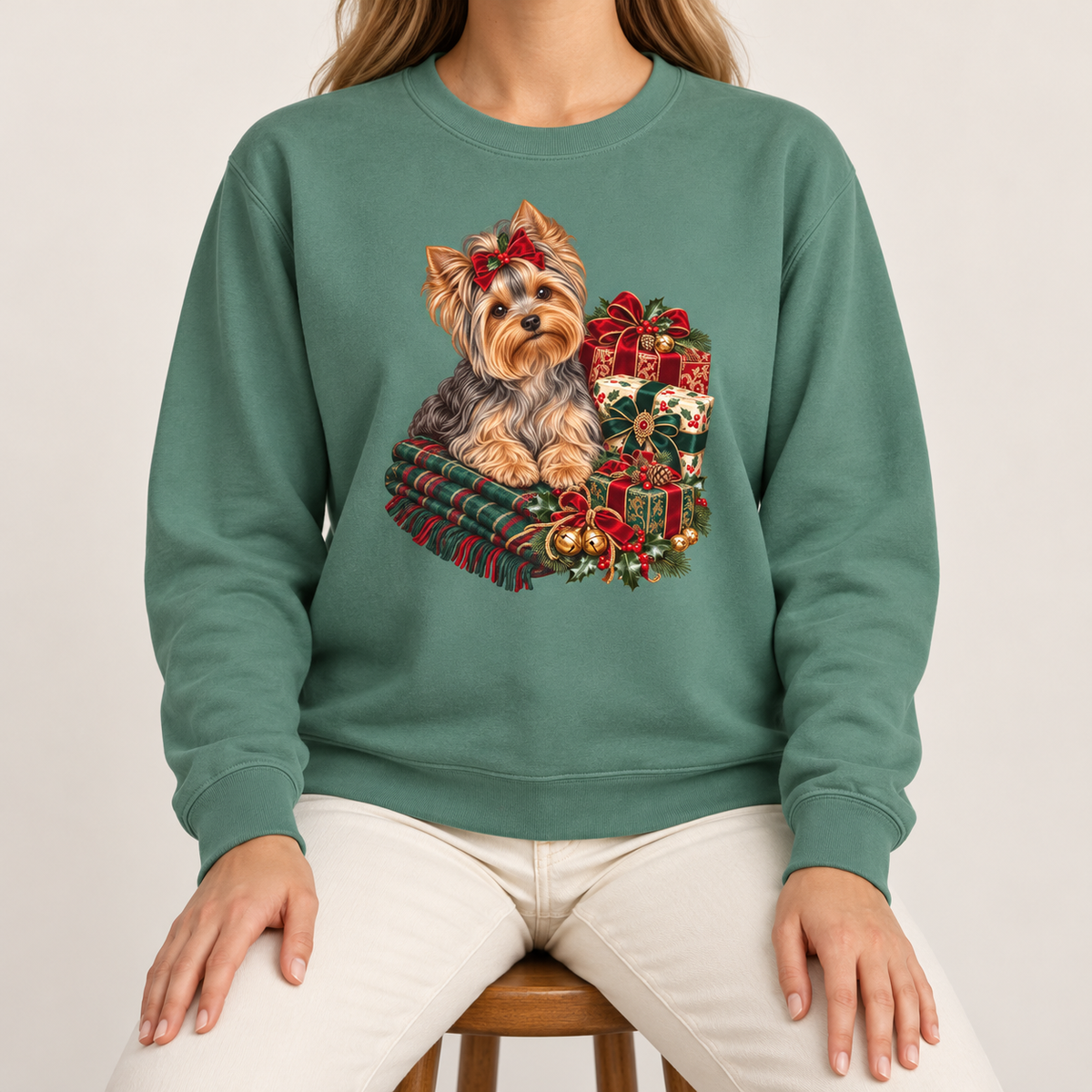 Yorkie Christmas sweatshirt – a Yorkshire terrier with a red bow on a tartan blanket beside wrapped Christmas presents, printed large on the chest of a Comfort Colors crewneck