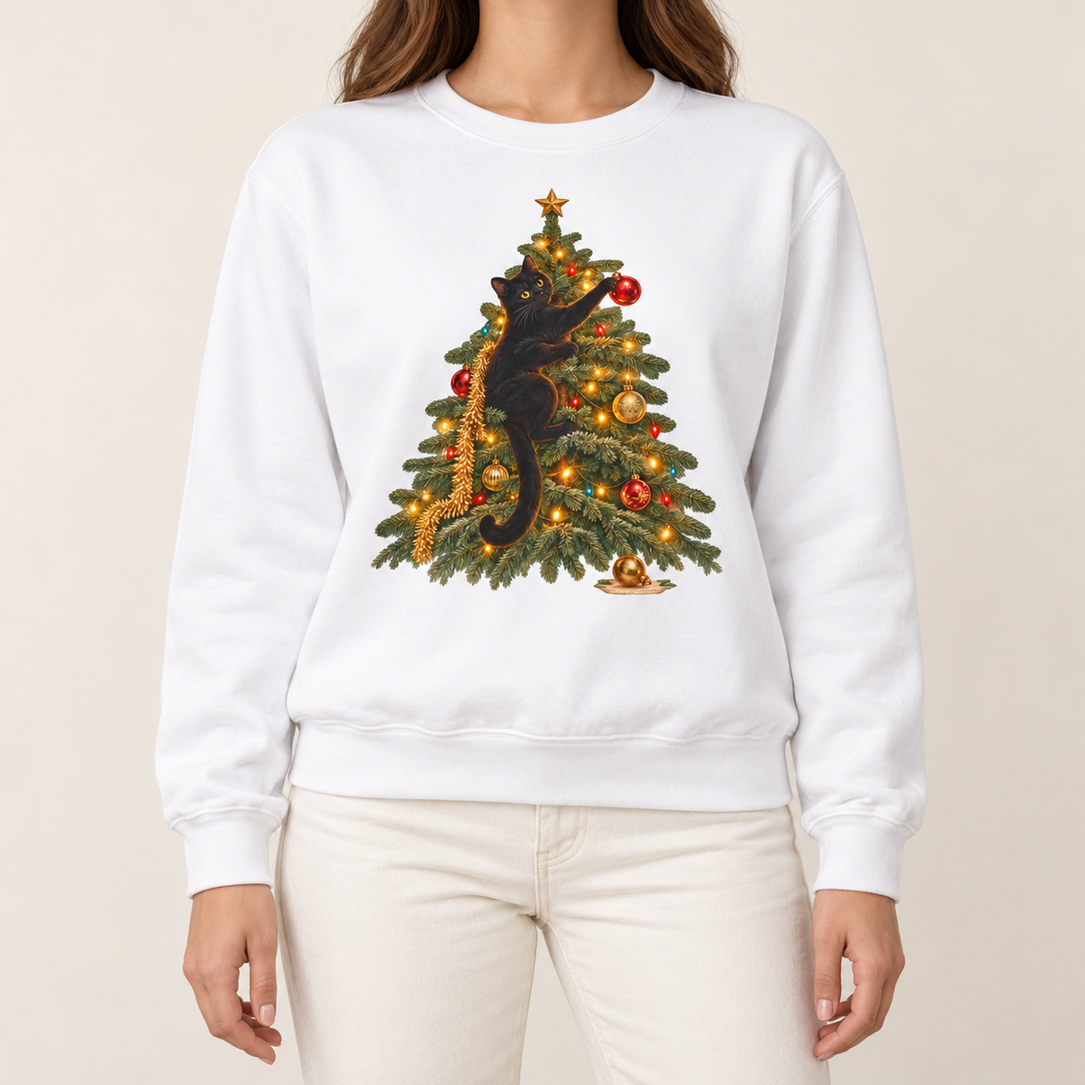 Black cat Christmas sweatshirt in White worn with jeans – black cat climbing a lit Christmas tree, reaching for a red ornament, Comfort Colors crewneck