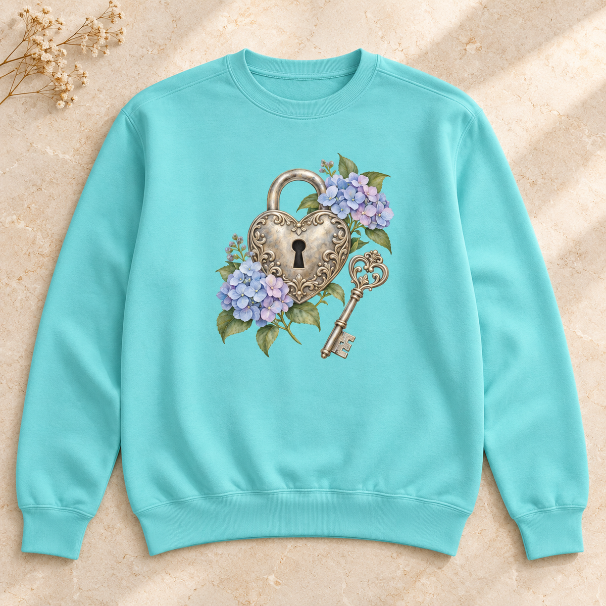 Detailed watercolor of a silver filigree heart padlock and skeleton key among blue and purple hydrangeas, printed large and centered on the front of a Chalky Mint pale mint 9.5 oz garment-dyed Comfort Colors 1566 sweatshirt, shown flat